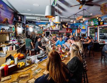 a packed bar with televisions and local decor in surf city nc