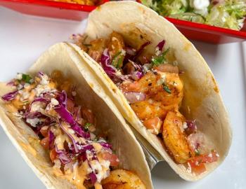 two shrimp tacos topped with slaw at a surf city restaurant