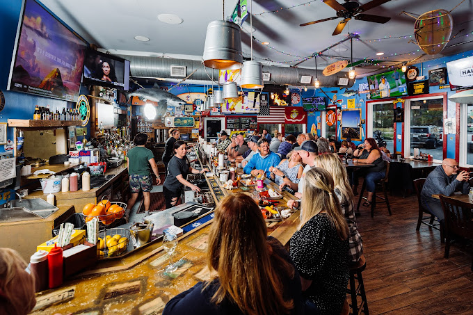 a packed bar with televisions and local decor in surf city nc